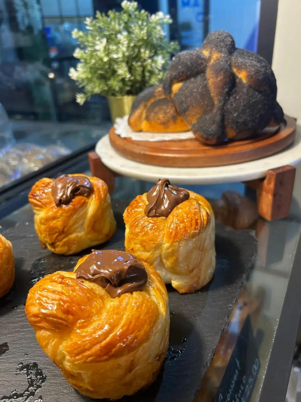 Vitrina con pan dulce recién horneado: chocolatines, conchas y bollería