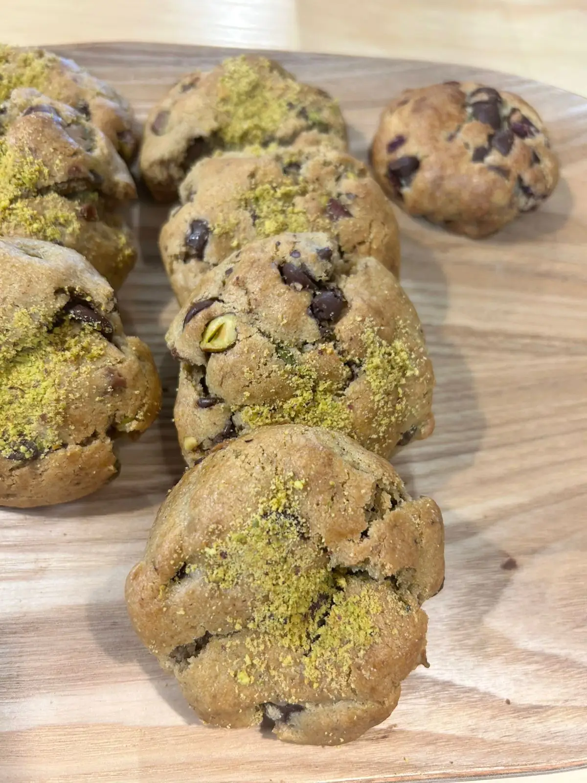 Galletas de pistache y de chispas de chocolate sobre tabla de madera