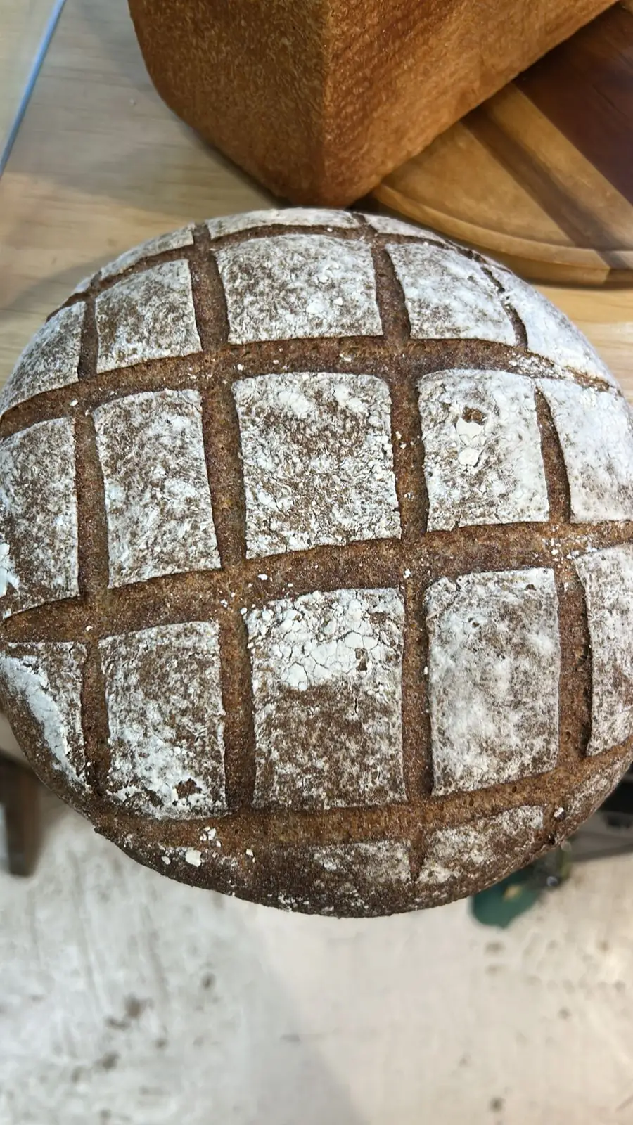 Hogaza de masa madre con greñado en cuadrícula hecho a navaja antes del horneado