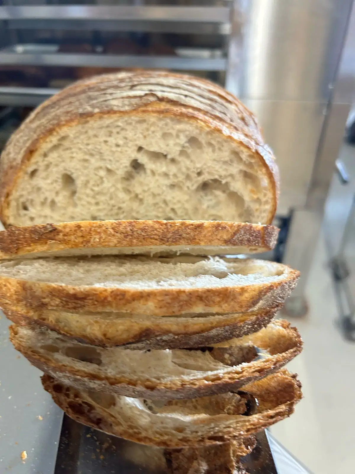 Pan de masa madre rebanado mostrando la miga alveolada de fermentación larga